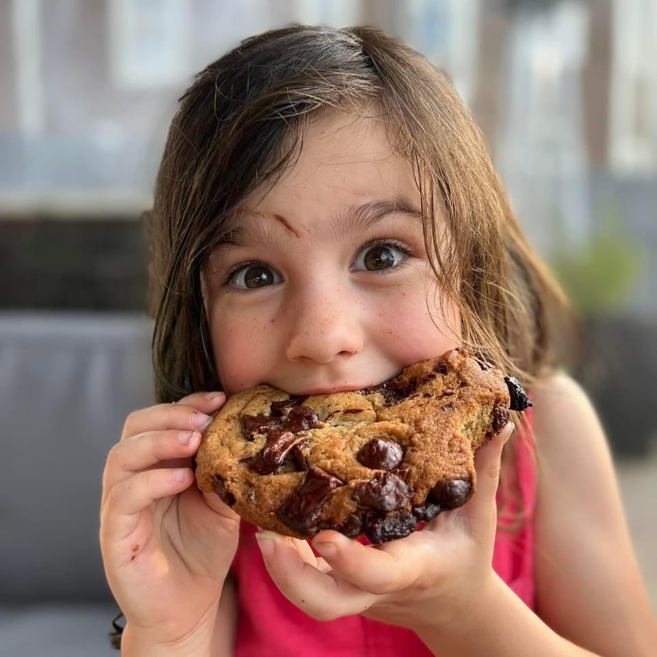 Young guest enjoying a chocolate chip cookie.