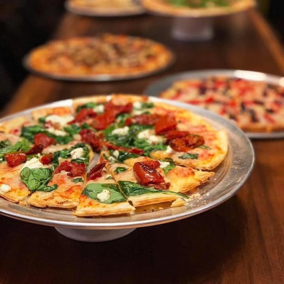 Pizzas on serving stands.